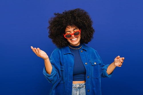 Happy young woman having fun with sunglasses in a studio