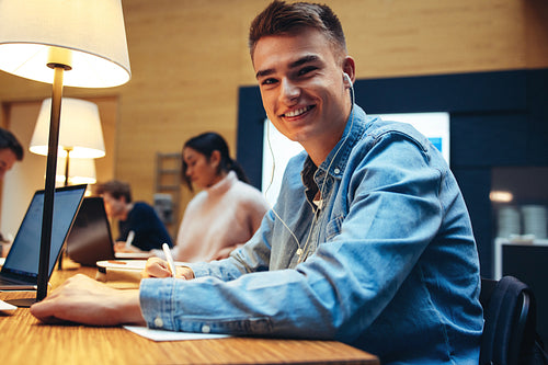 Young male studying in university library