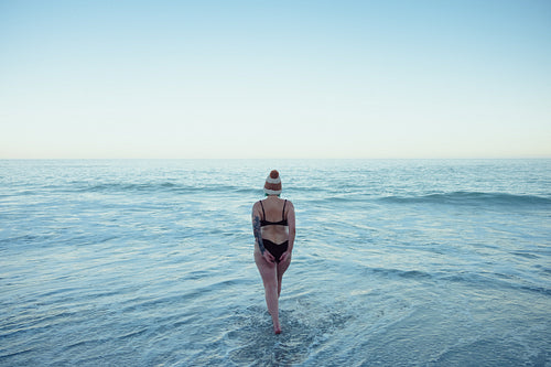 Anonymous woman going into the sea water in winter