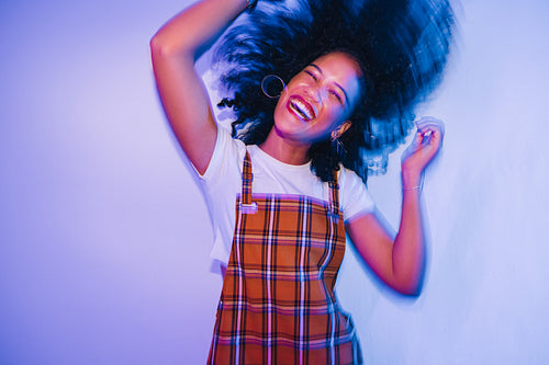 Energetic young woman dancing and whipping her hair