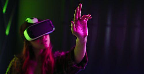 Woman wearing a VR headset, interacting with objects in the virtual world