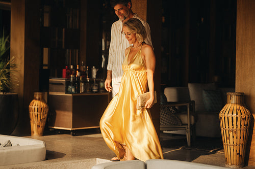 Woman in golden dress and man enjoying their date in a stylish restaurant