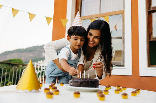 Mother and son celebrating a birthday with cake and decorations
