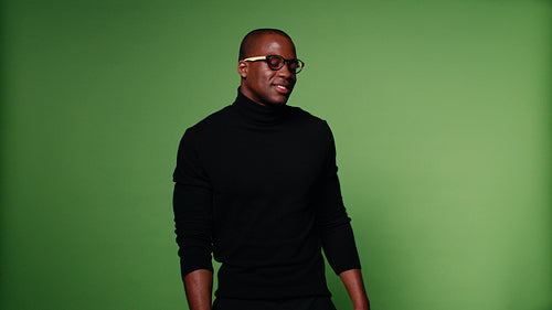 Stylish African-American man dances rhythmically against a green screen