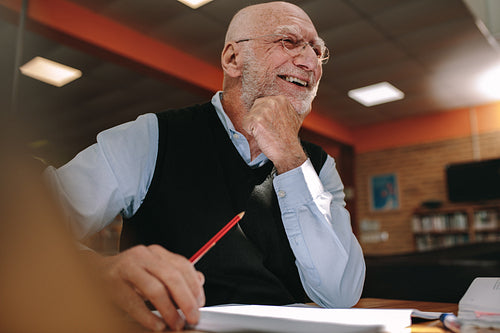 Portrait of a smiling senior man sitting in a library