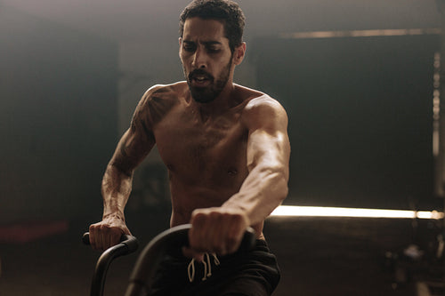 Fitness man on bicycle doing spinning at gym