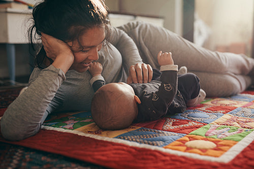 Mother lying on bed with her baby
