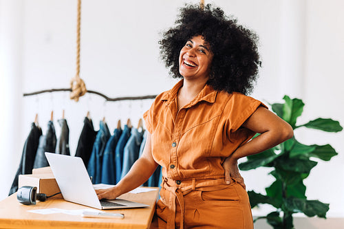 Black small business owner smiling at the camera in her shop
