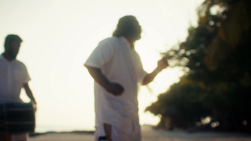 Traditional Bodu Beru dancers move to rhythmic drumming on the beach at sunset