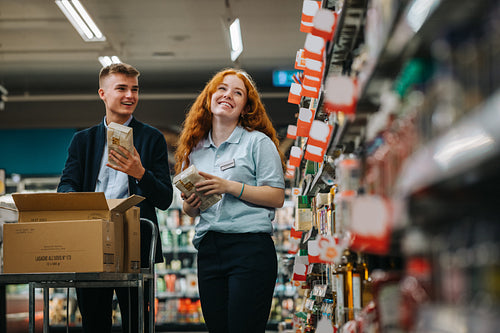 Supermarket workers restocking the shelves