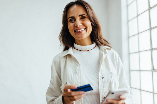 Business woman using a credit card to make mobile payments for her startup