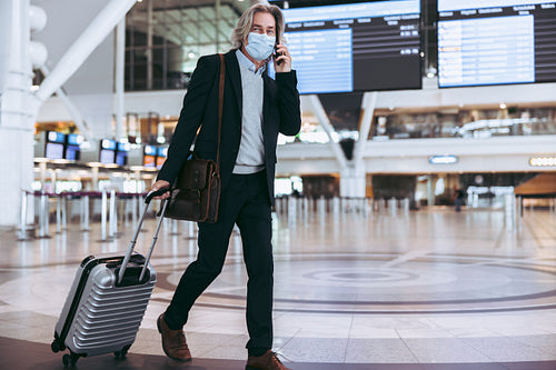Businessman on phone at airport terminal