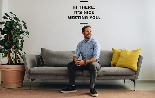 Confident freelancer sitting on sofa