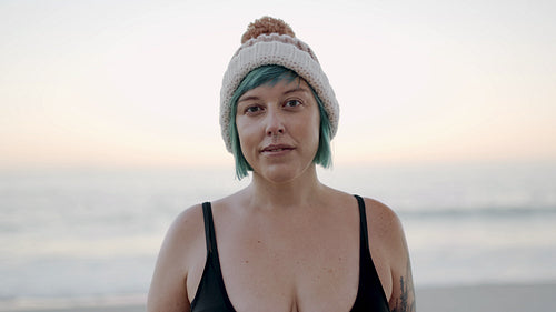 Woman in bikini and woolly hat on the beach