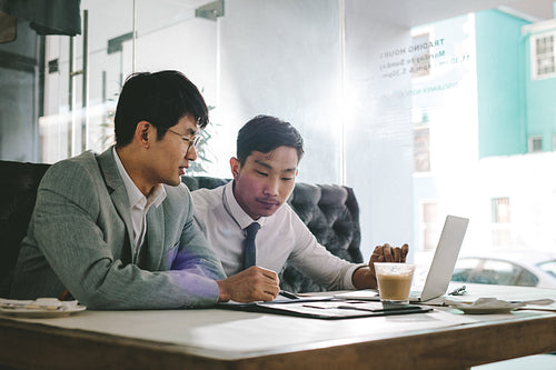 Two businessmen working together in coffee shop