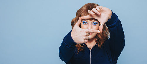 Woman making a finger frame in a studio