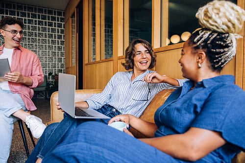 Group of professionals laughing and discussing ideas in a cozy office setting
