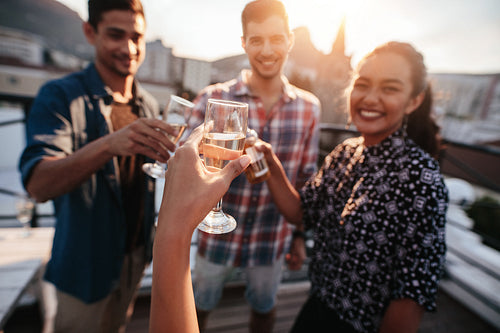 Young friends hanging out and enjoying with drinks.