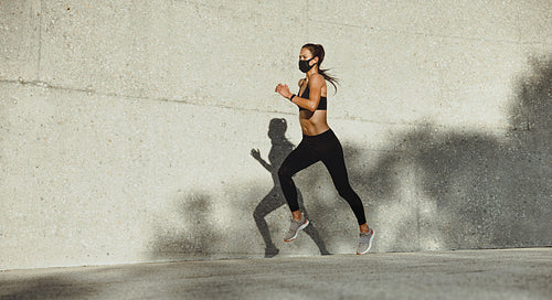 Woman on a morning run with face mask