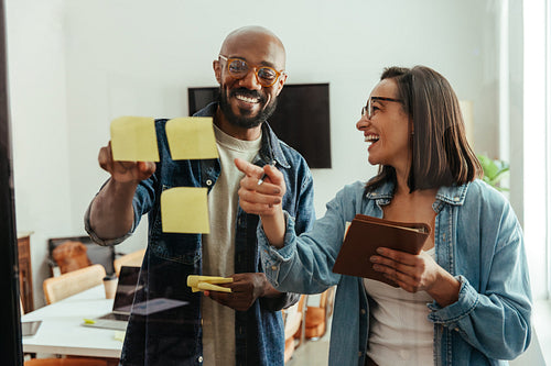 Creative business team brainstorming ideas with sticky notes in modern office
