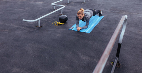 Fitness woman doing push-ups at outdoor gym
