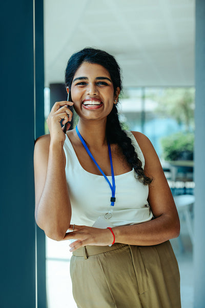 Friendly Indian businesswoman talking on smartphone in office