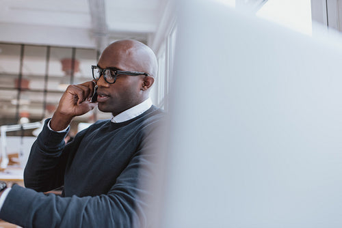 Businessman talking on cellphone while at work