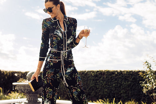 Beautiful woman with wine walking outdoors