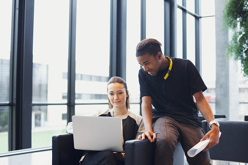 Two young students using laptop in campus