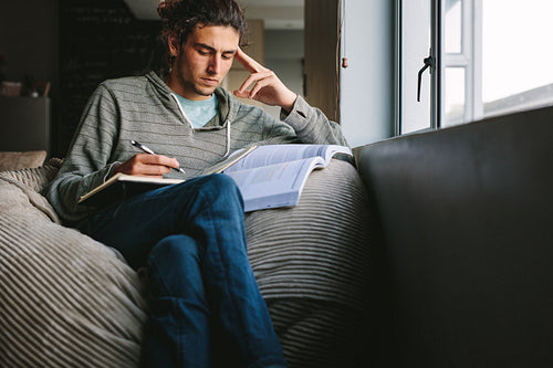 Student studying at home sitting beside a window