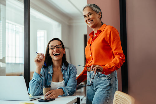 Happy women employees collaborating in a modern office