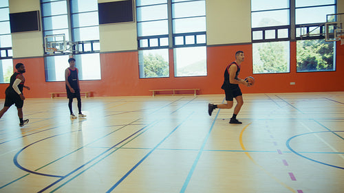 Active men playing basketball together
