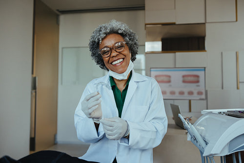 Confident female dentist presenting clear aligners in modern clinic