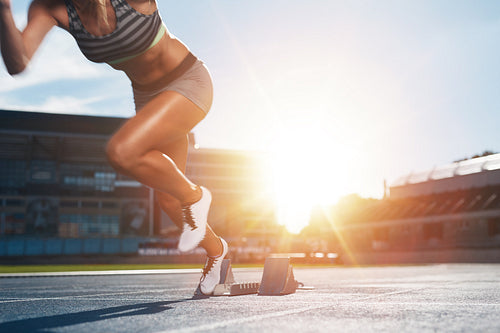 Female athlete launching off the start line in a race