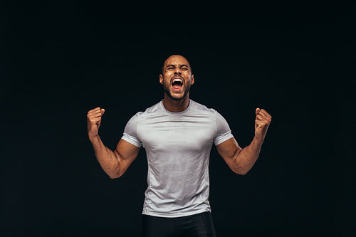 Muscular athlete shouting in joy