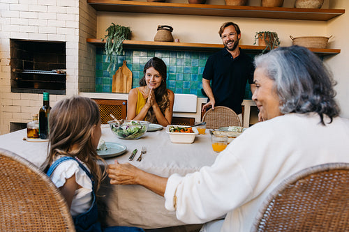 Family gathering around table in cozy kitchen