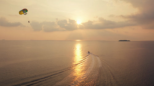 Parasailing adventure over the beautiful ocean at sunset with a speedboat
