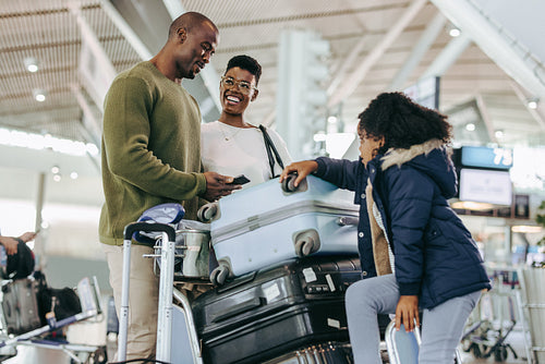 African family of three waiting at airport