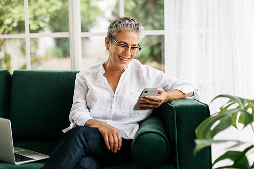 Elderly woman calling her friends and family using a mobile phone at home