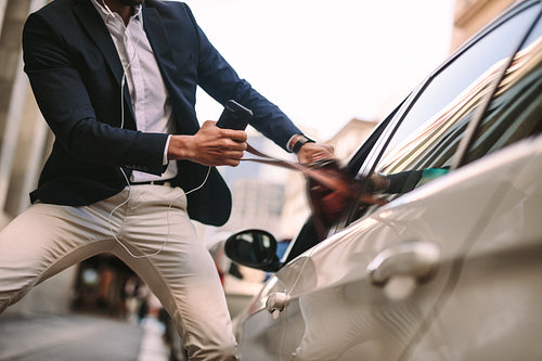 Businessman pulling out his handbag from a car