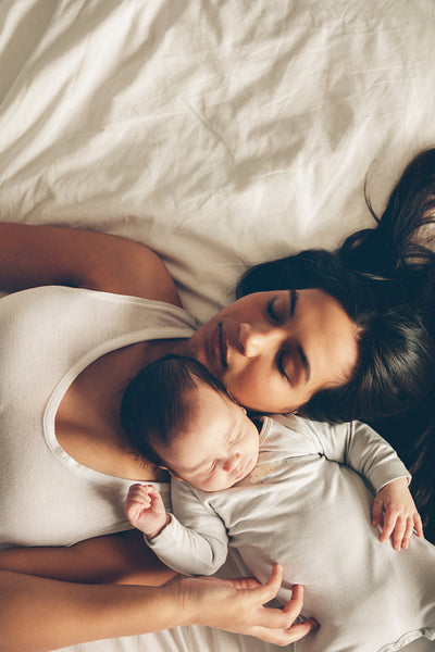 Mother and son sleeping together on bed