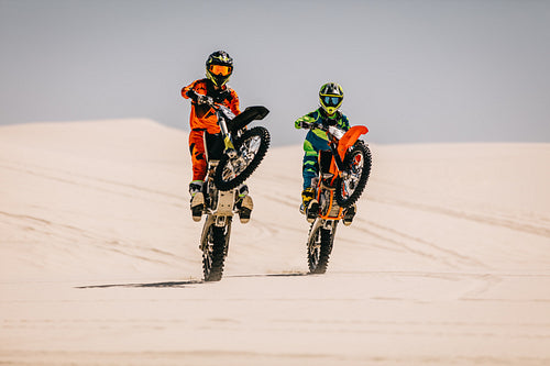 Moto racers executing synchronized wheelie