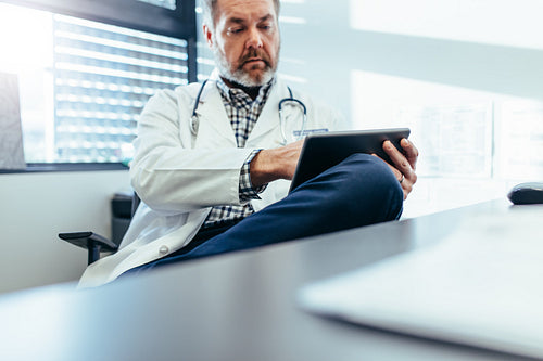 Medical practitioner using tablet pc in his clinic