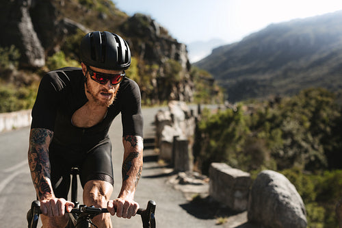Sportsman cycling road bike on mountain road