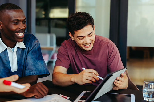 College students engaged in collaborative learning with technology, enjoying a productive study session using a digital tablet