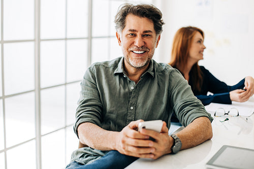 Business man smiling at the camera in a boardroom