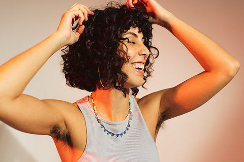 Happy young woman embracing her natural body hair