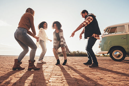 Friends dancing outdoors on road