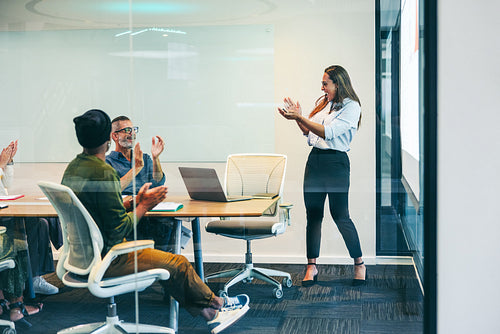 Cheerful businesspeople applauding their success in a boardroom