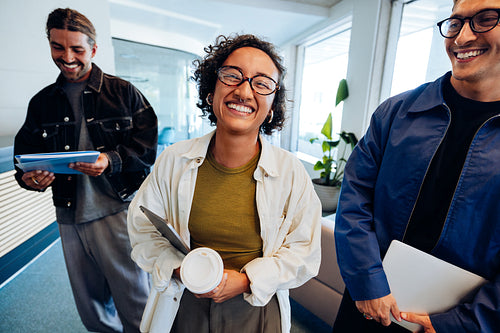 Three professionals smile in hallway after meeting
